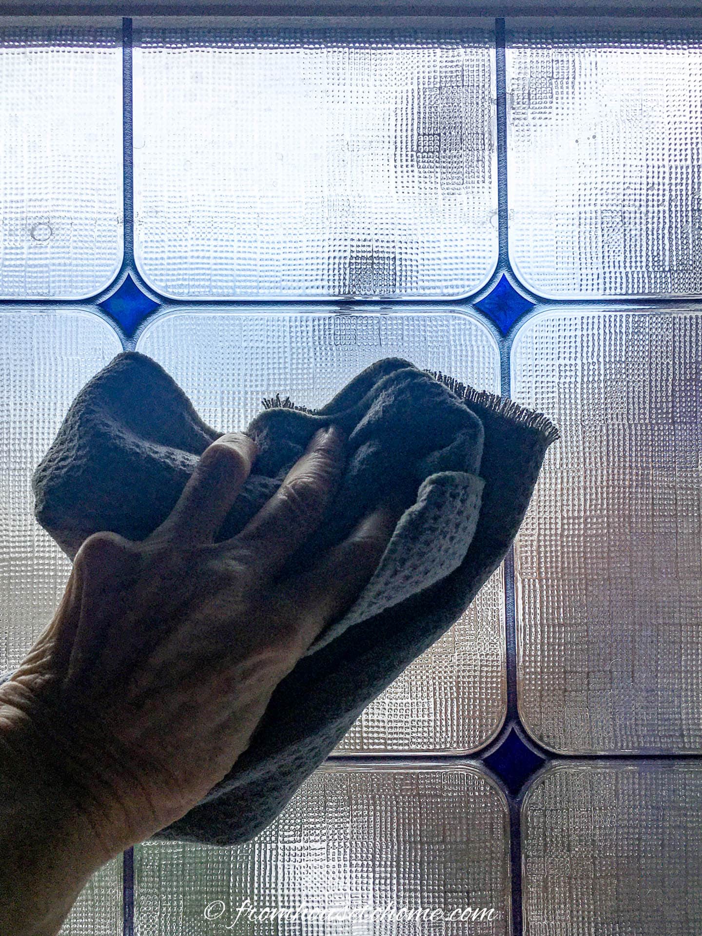 A wash cloth wiping the window film after it has been cleaned