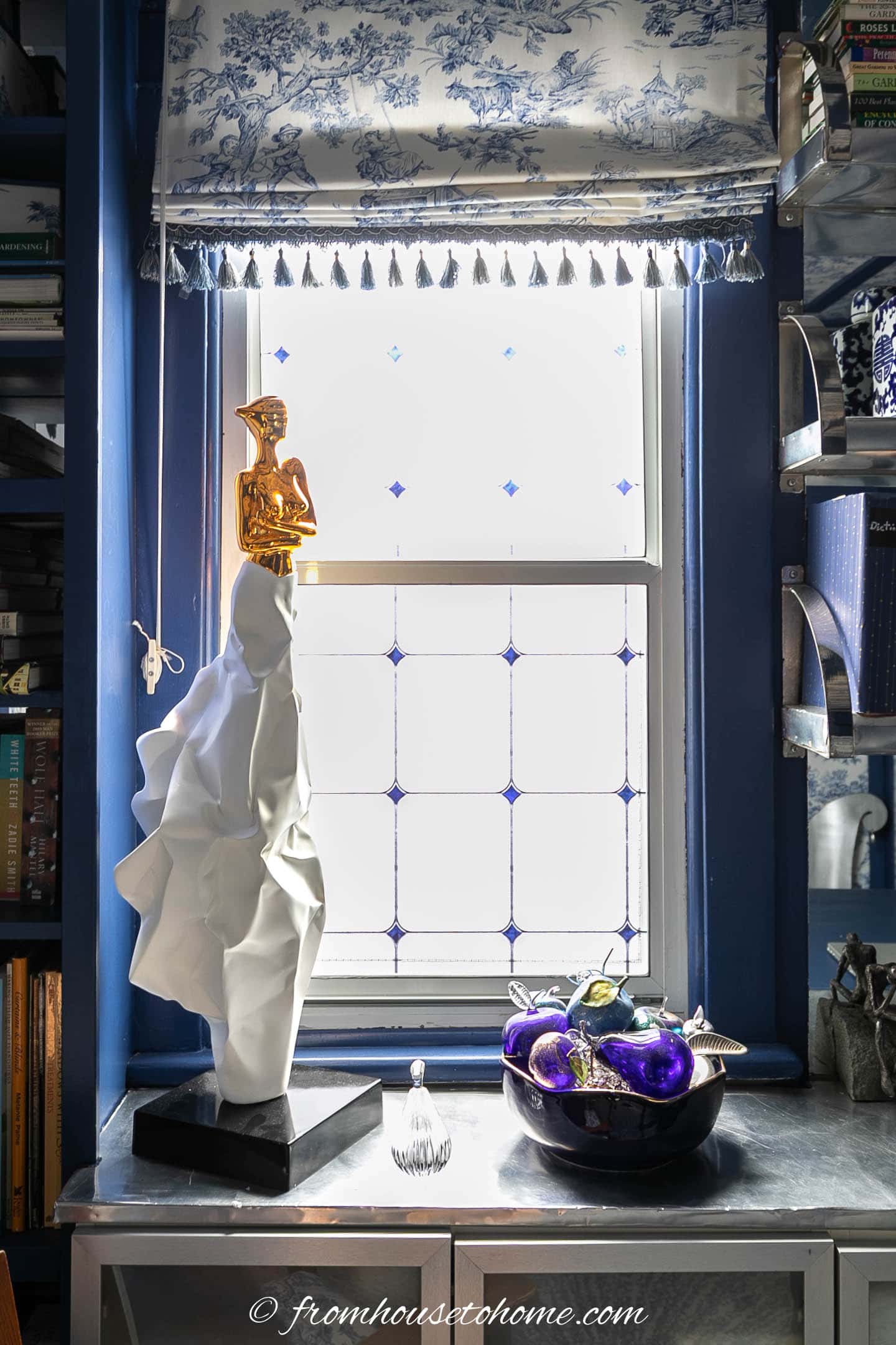A window covered with vinyl window film with a statue and some other accessories in front of it