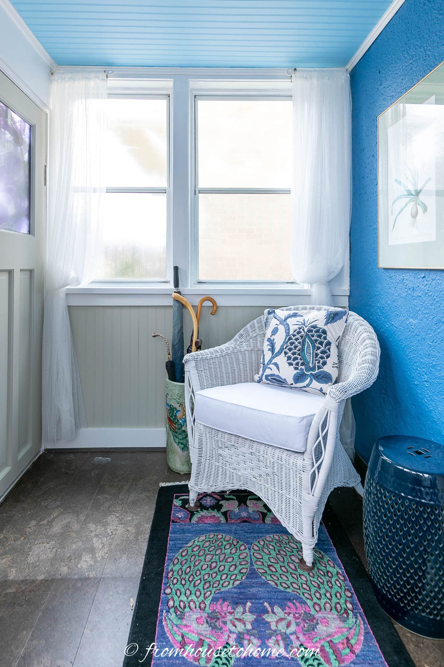 White and blue chair beside a dark blue ceramic garden stool in a blue and white front porch