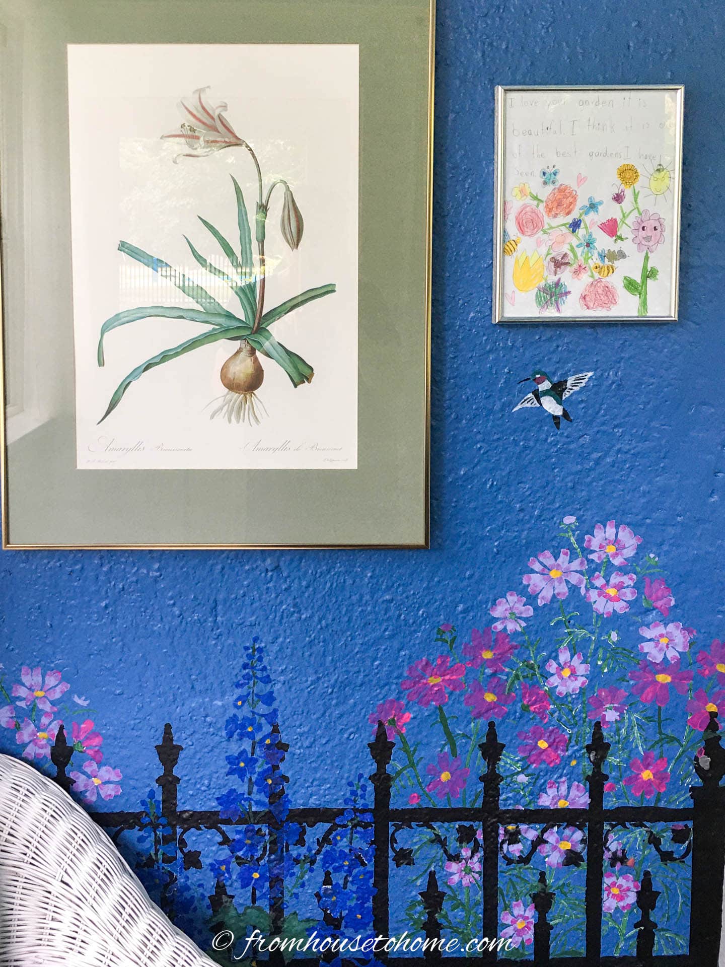 A dark blue wall with floral artwork above a stenciled garden scene