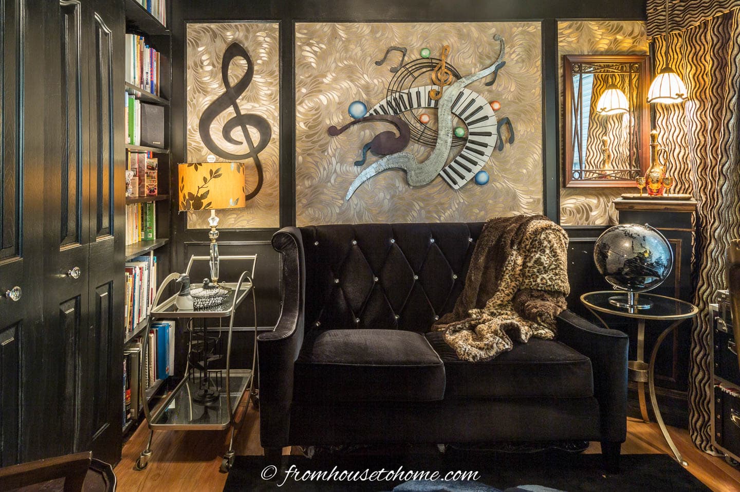 A loveseat with a leopard print throw beside the built-in bookcases in a small home office library
