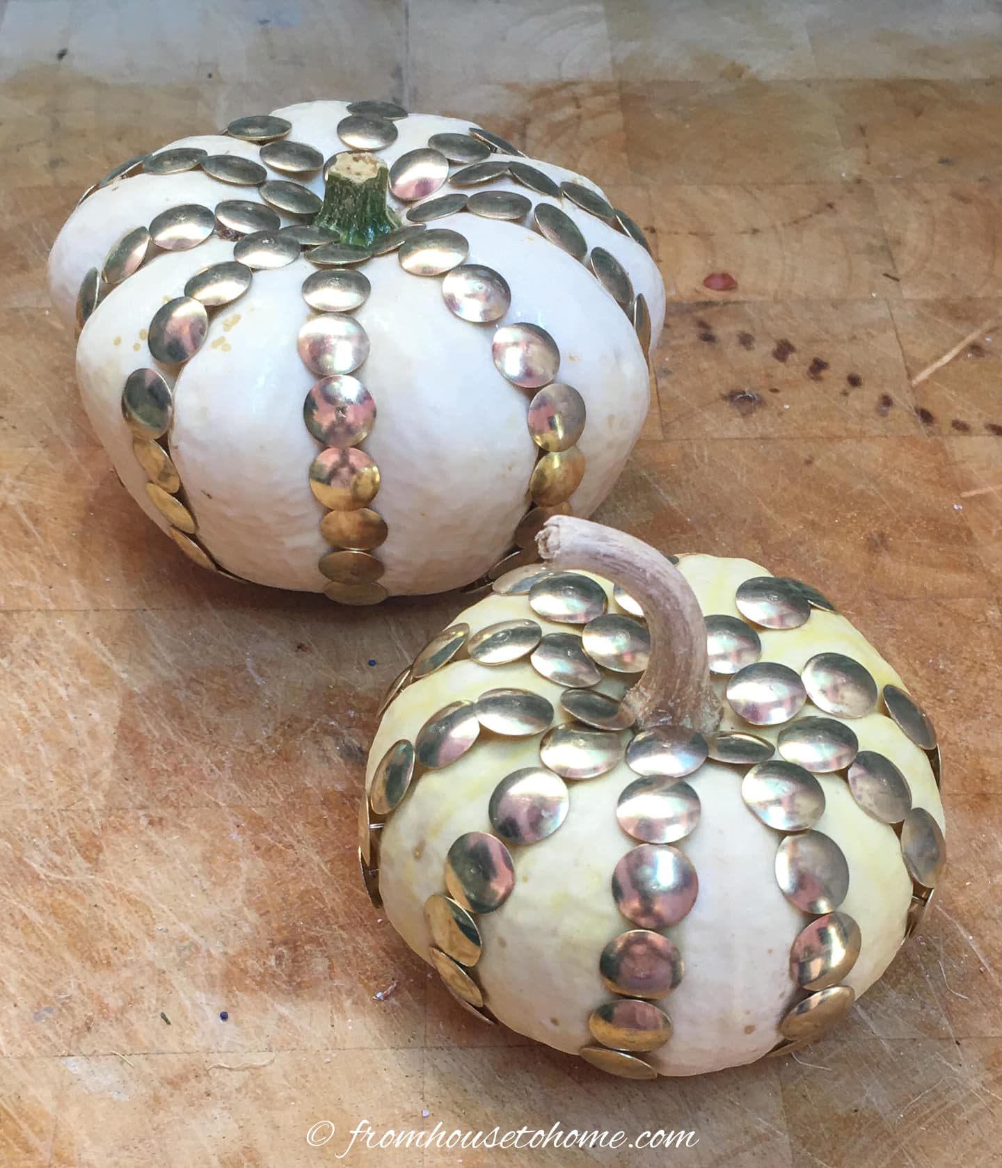 Fall home decor ideas featuring white and gold pumpkins on a cutting board.