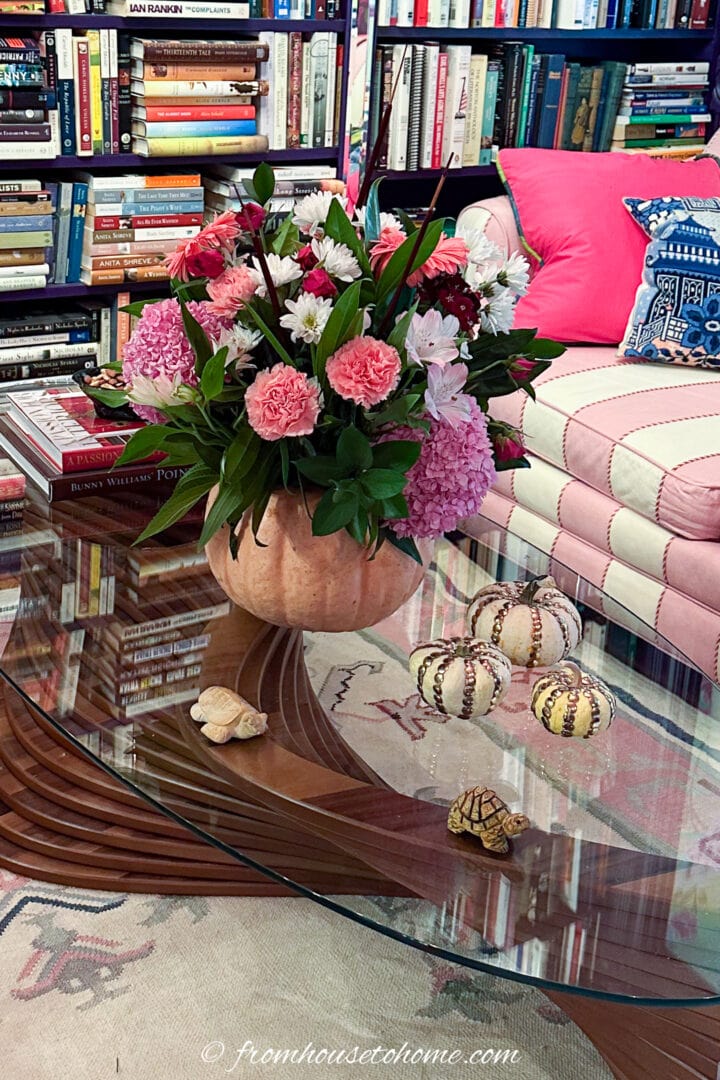 DIY pumpkin vase with pink flowers on a glass coffee table