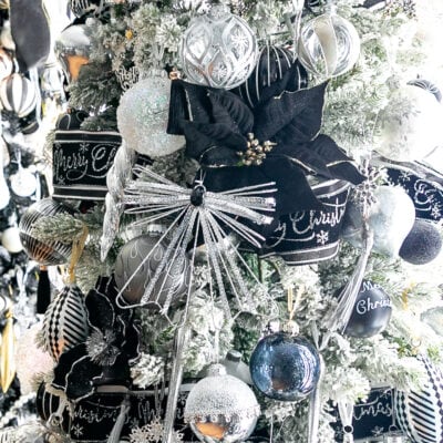 Close up of a Christmas tree decorated with silver, black and white ornaments