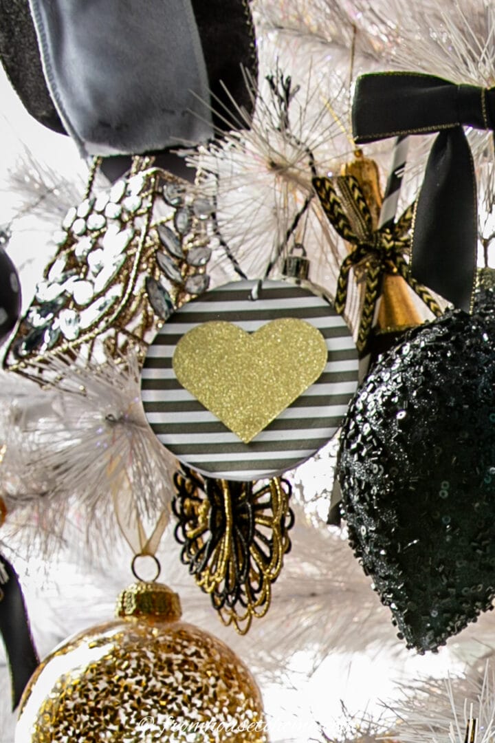 A DIY heart Christmas ornament hung on a white Christmas tree