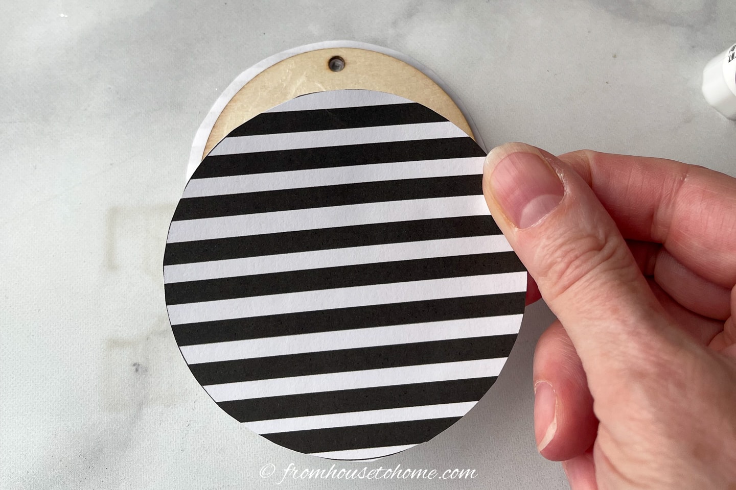 Black and white striped circle being glued to a wood disc