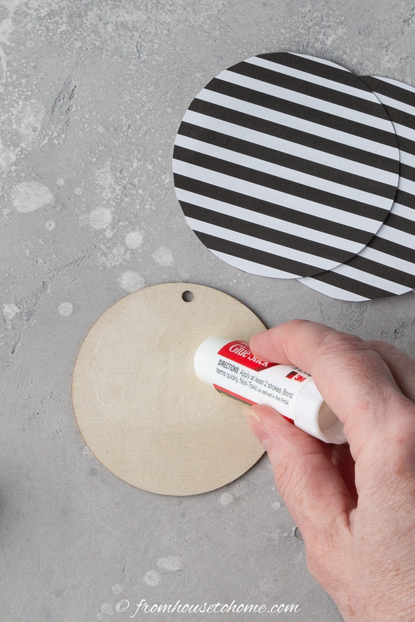 Glue being applied to a wood ornament disc