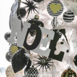 A black and white DIY letter ornament on a white Christmas tree