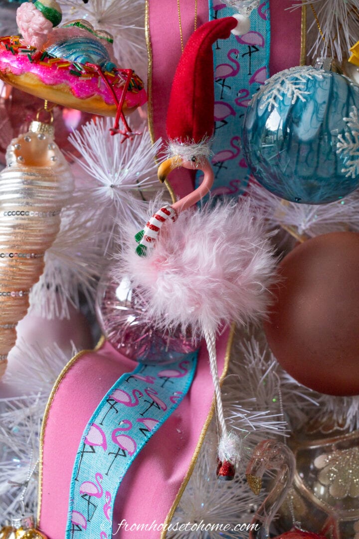 A flamingo ornament hung on a Christmas tree