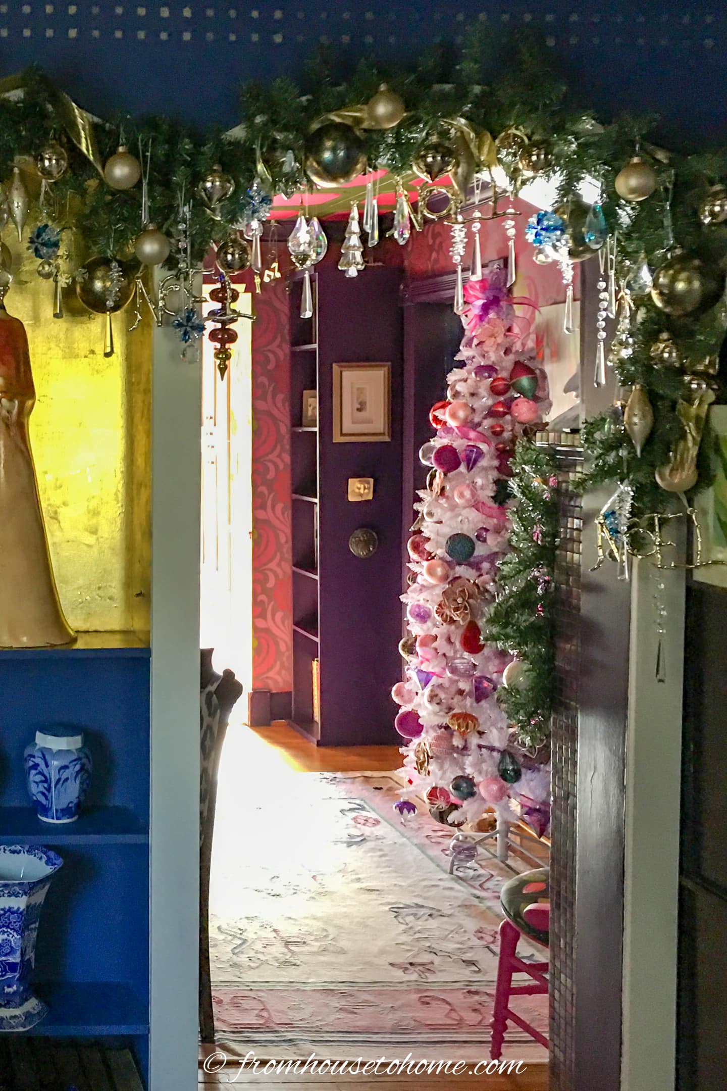 A living room with a Christmas tree decorated with purple and pink ornaments.