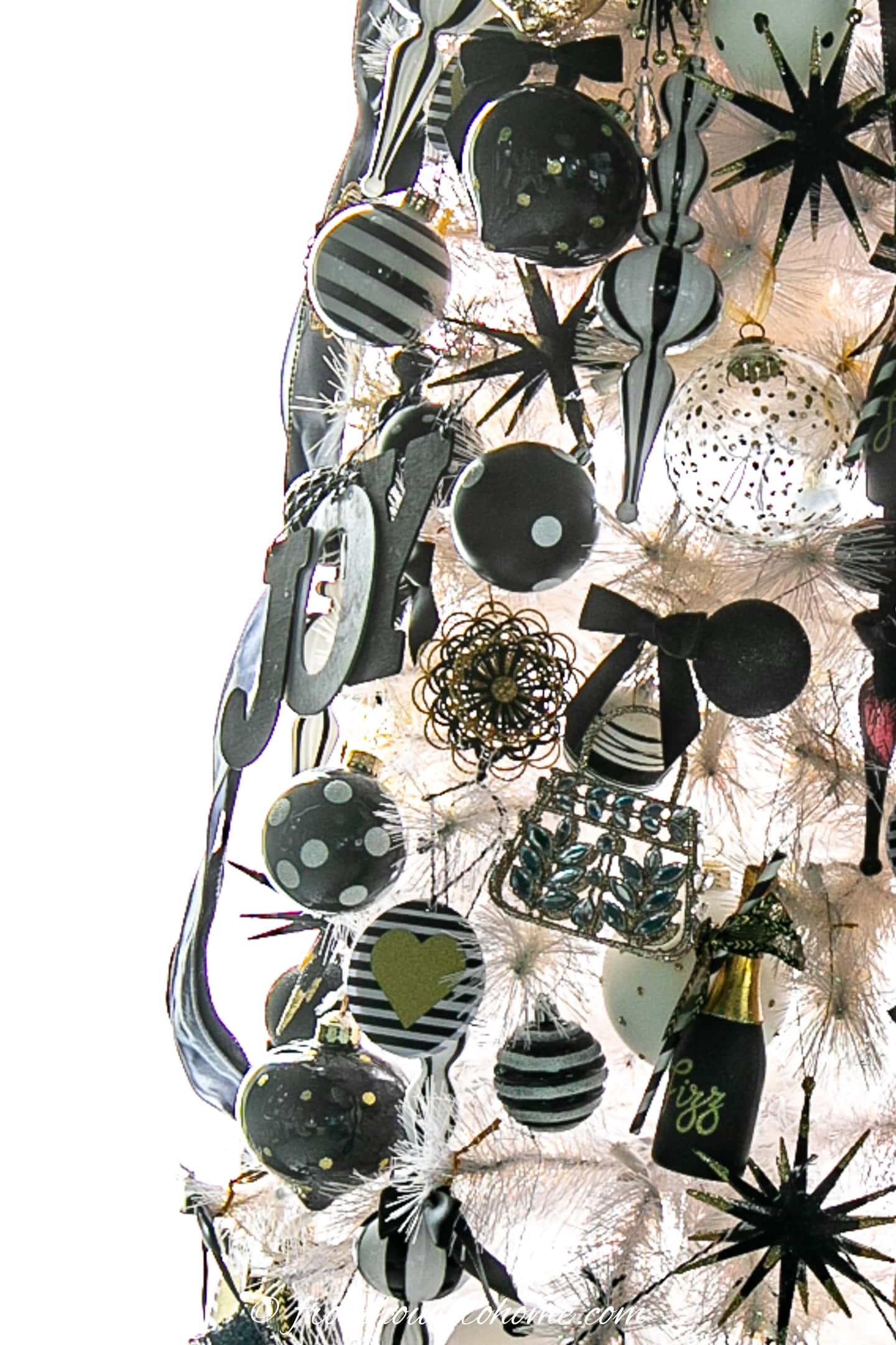 Side view of a white Christmas tree decorated with black and white ornaments.