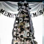 The top of a white Christmas tree with black decorations.