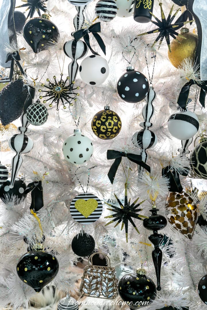 A close up picture of a white Christmas tree with black ornaments.