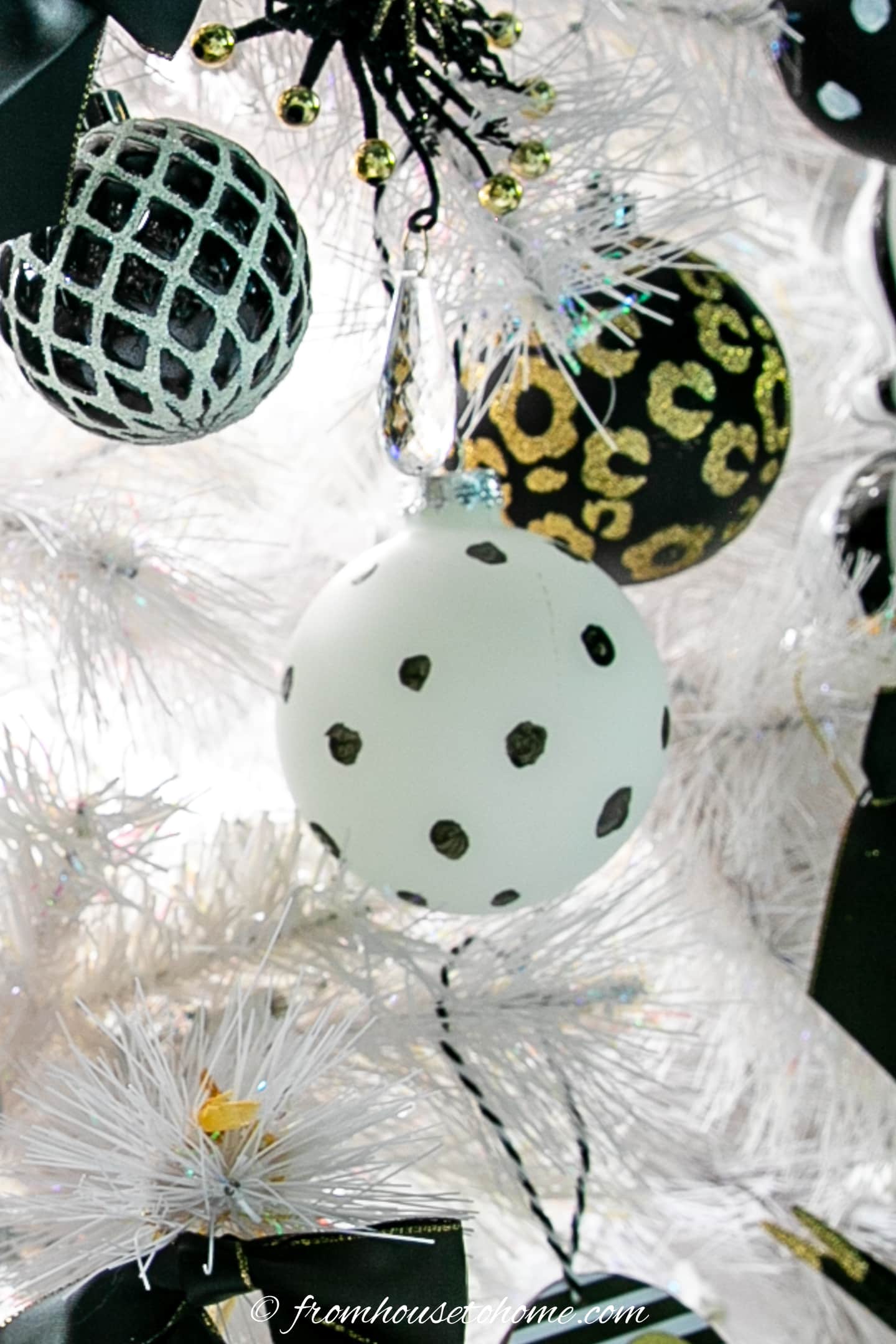 A white Christmas tree decorated with black and white polka dot ornaments.