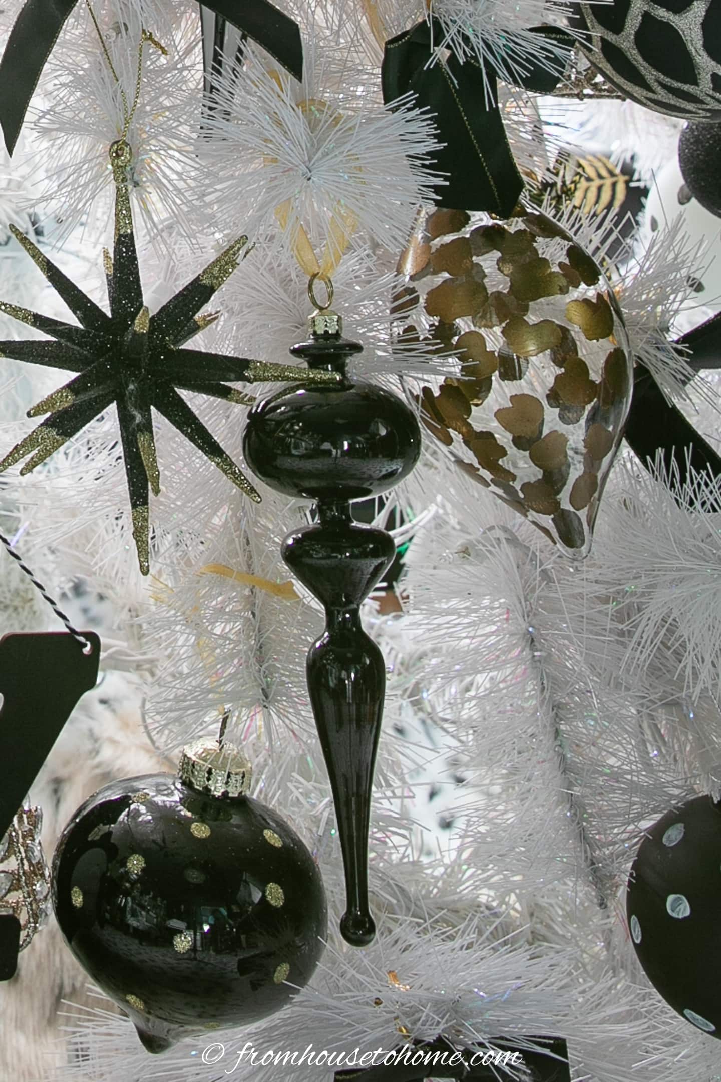 Long black finial ornament on a white Christmas tree