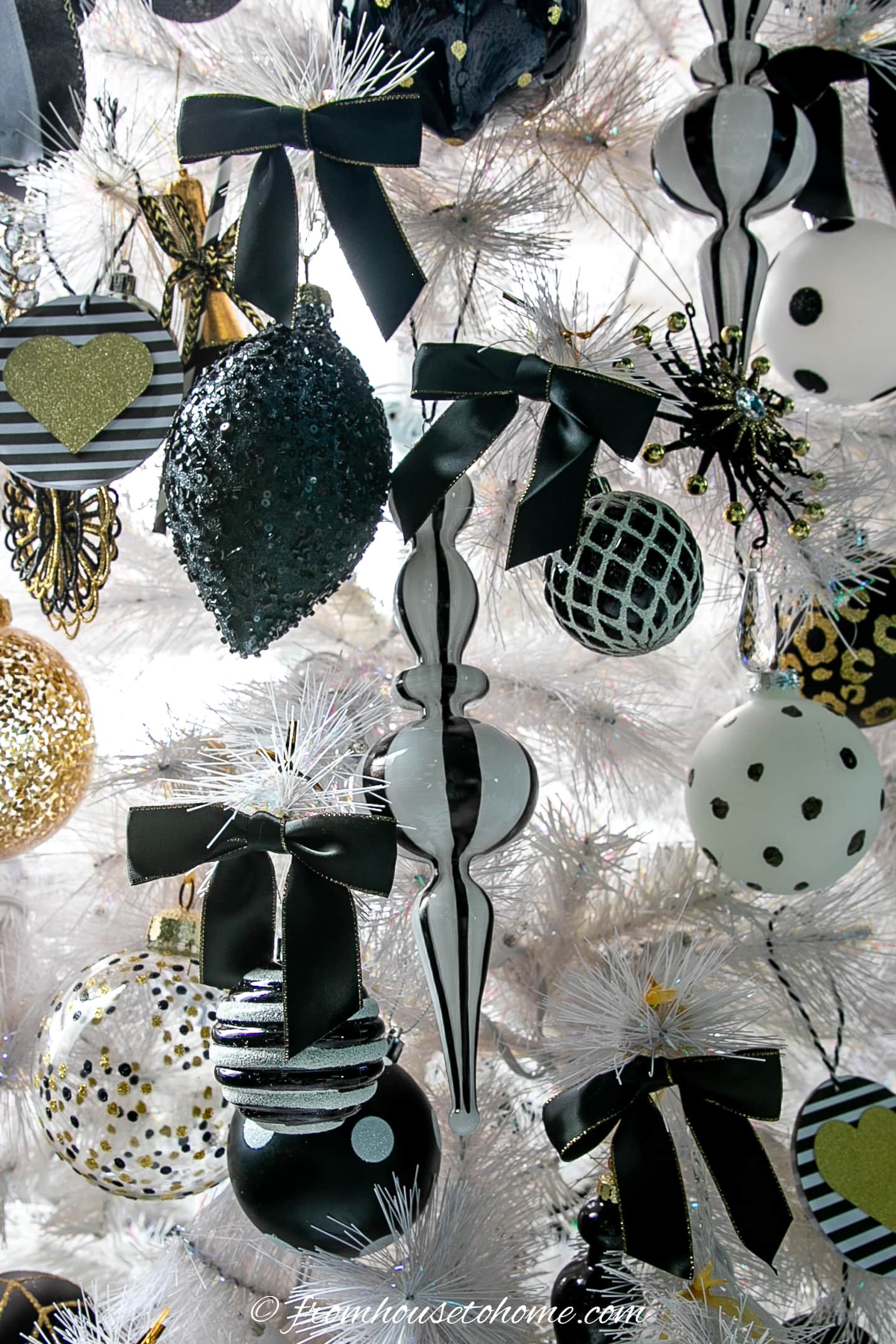 Black bows and other ornaments on a white tree
