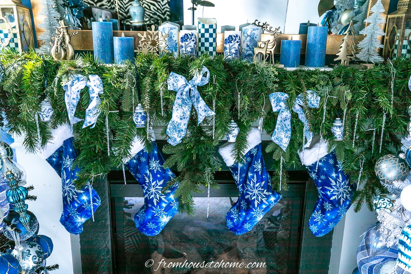 Garland decorated with blue and white ribbon hung over a fireplace mantel