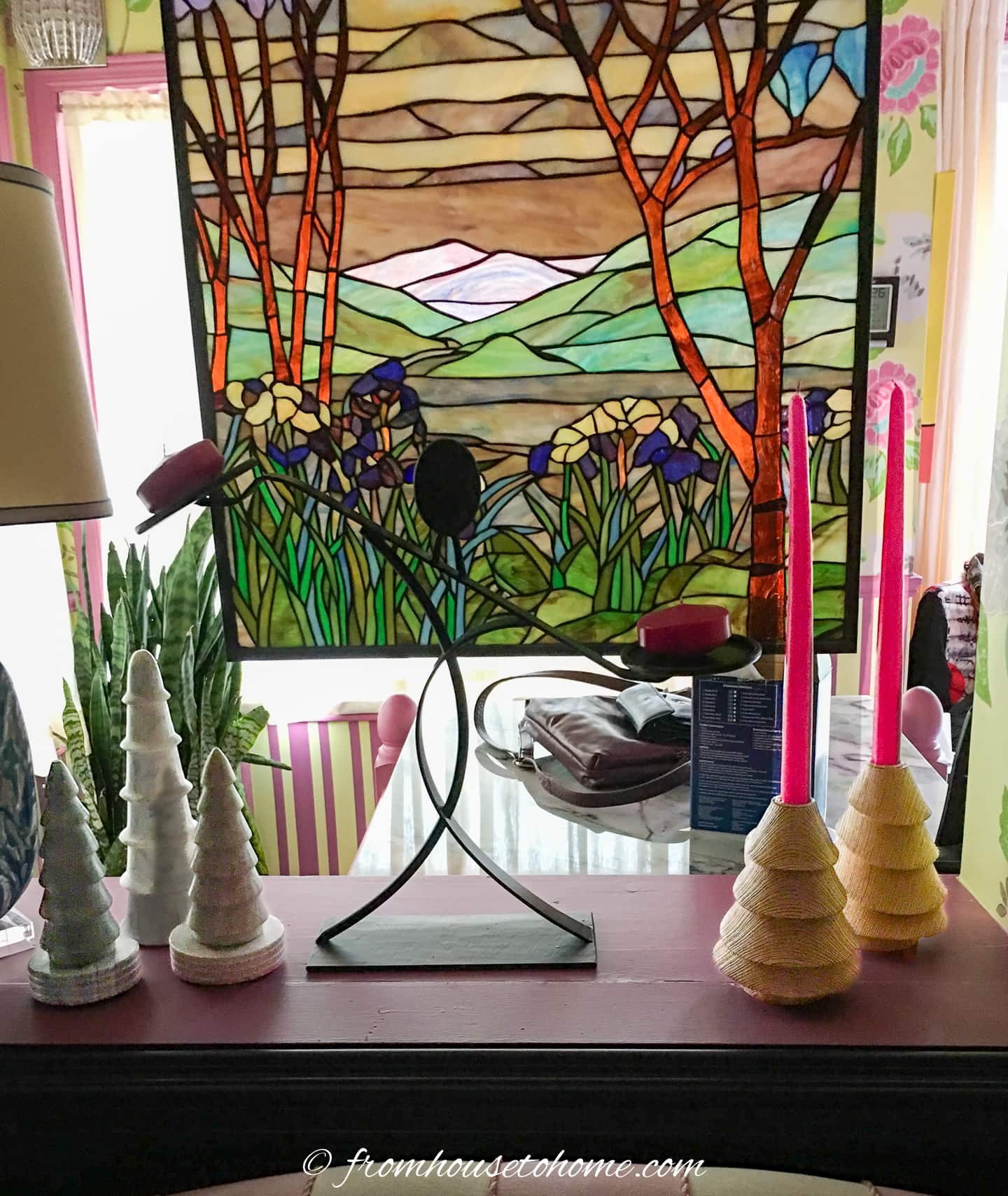 Candles and mini Christmas trees on a window ledge