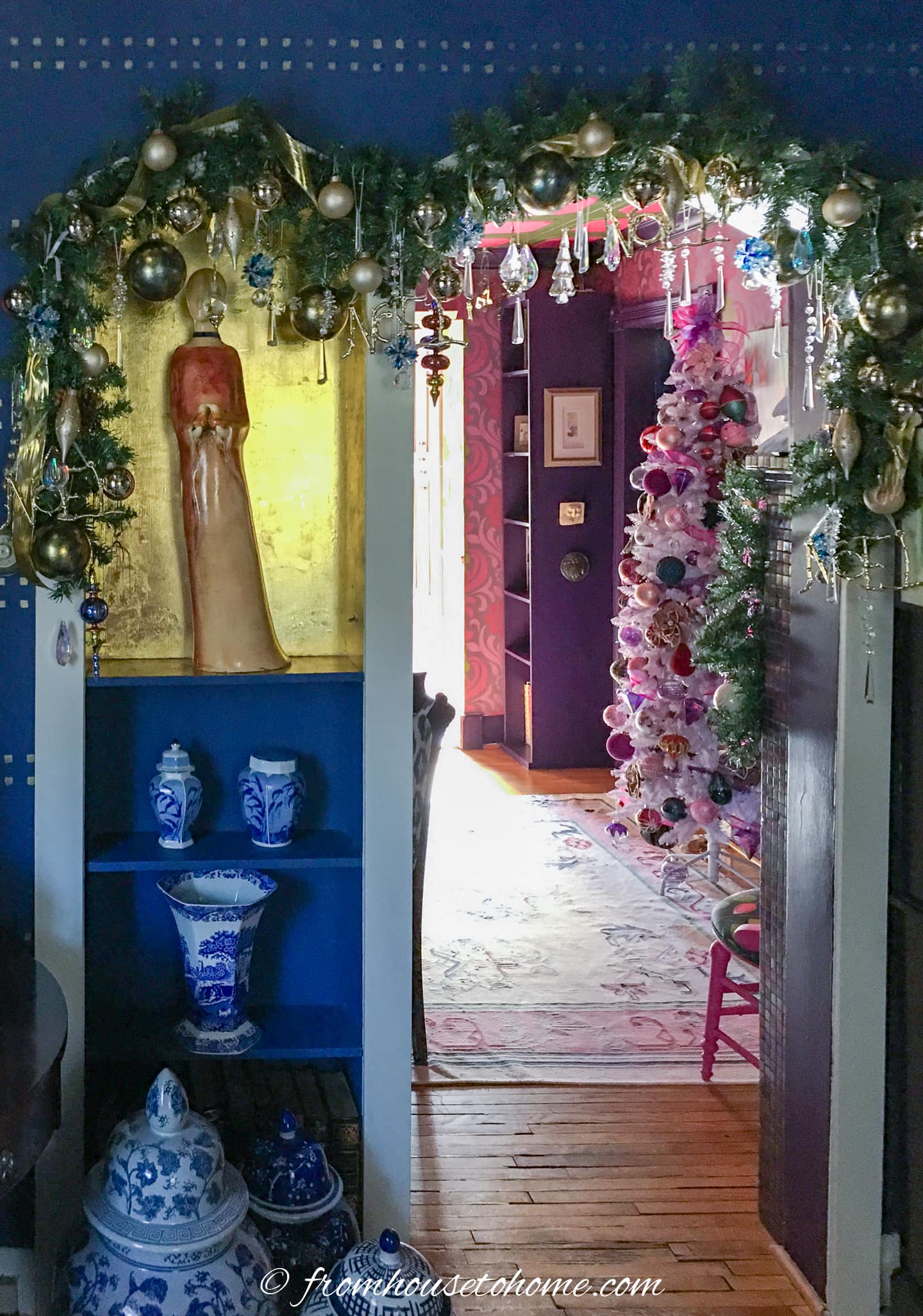 Blue room leading into a pink room with an indoor doorway Christmas garland hung between them