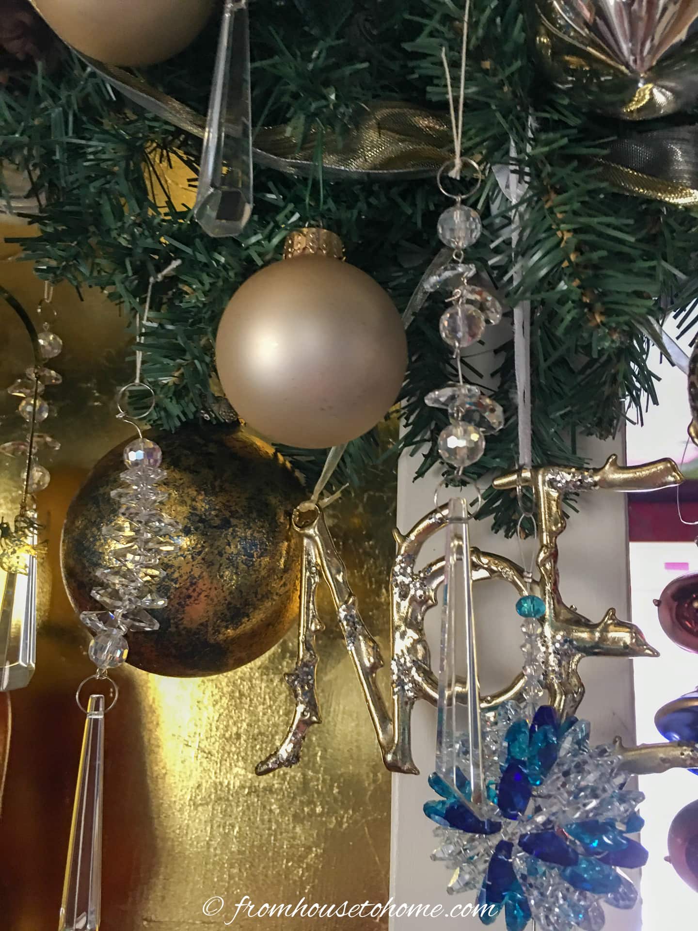 Gold and crystal ornaments hung on an indoor doorway garland