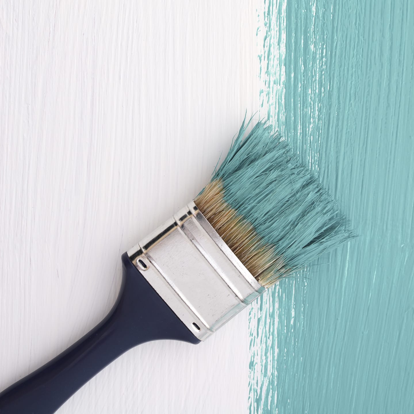a paint brush with green blue paint, one of the 2024 paint color trends