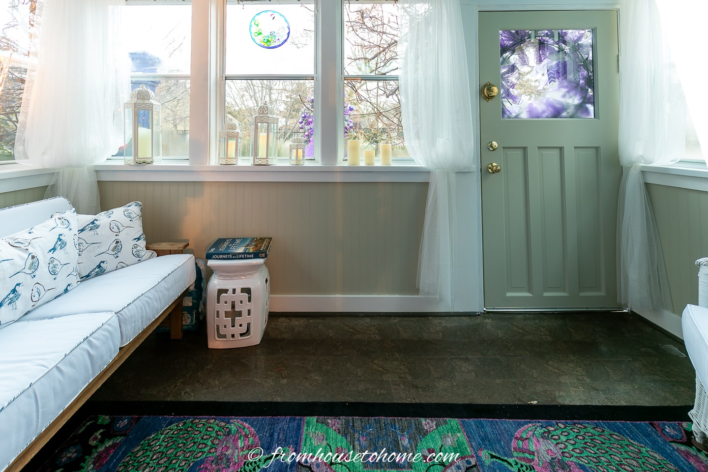 Front porch with blue and white sofa and white curtains
