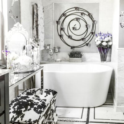 a freestanding tub in a grey, black and white bathroom