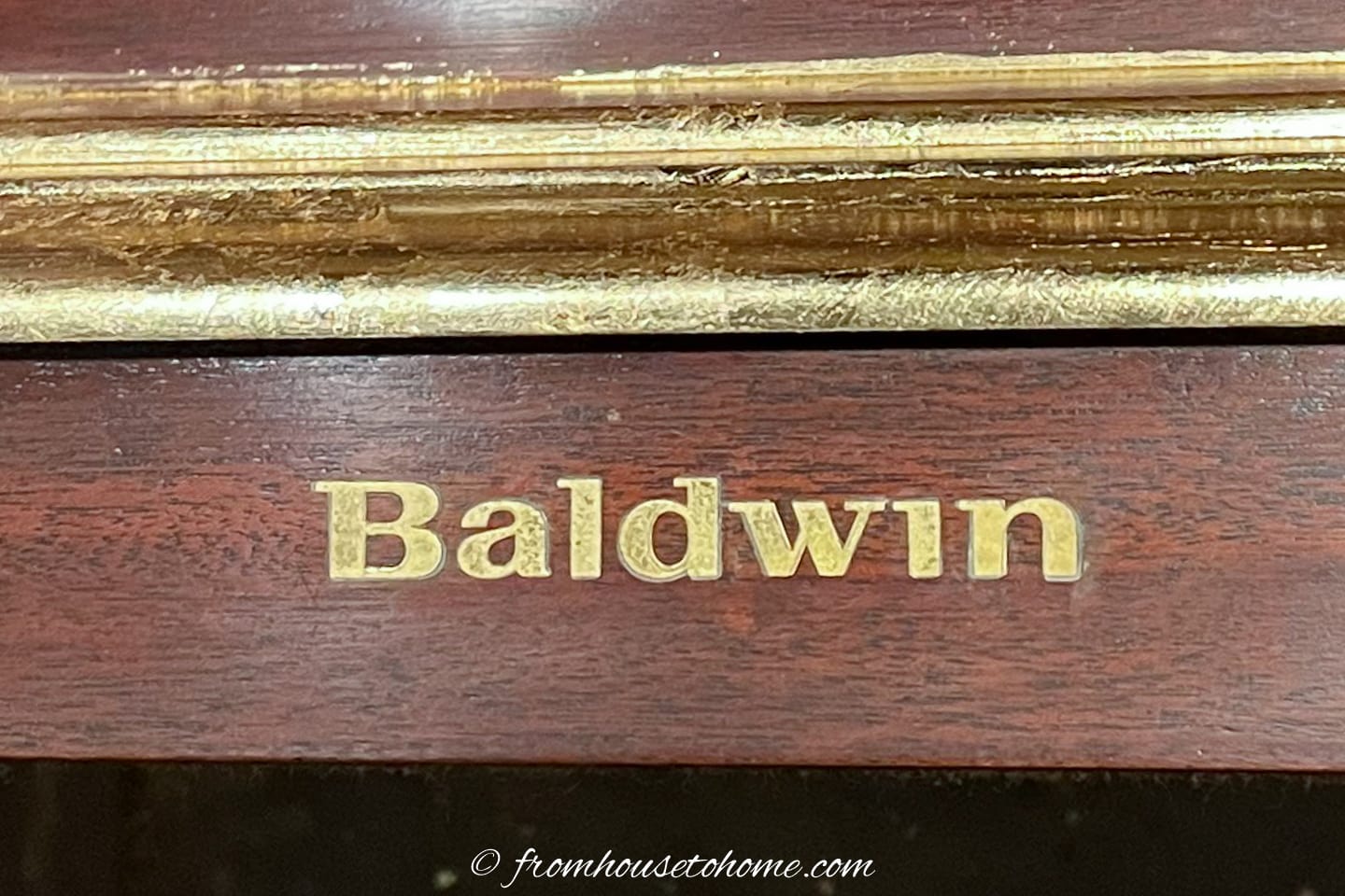Baldwin sign on the front of a piano covered with clear vinyl