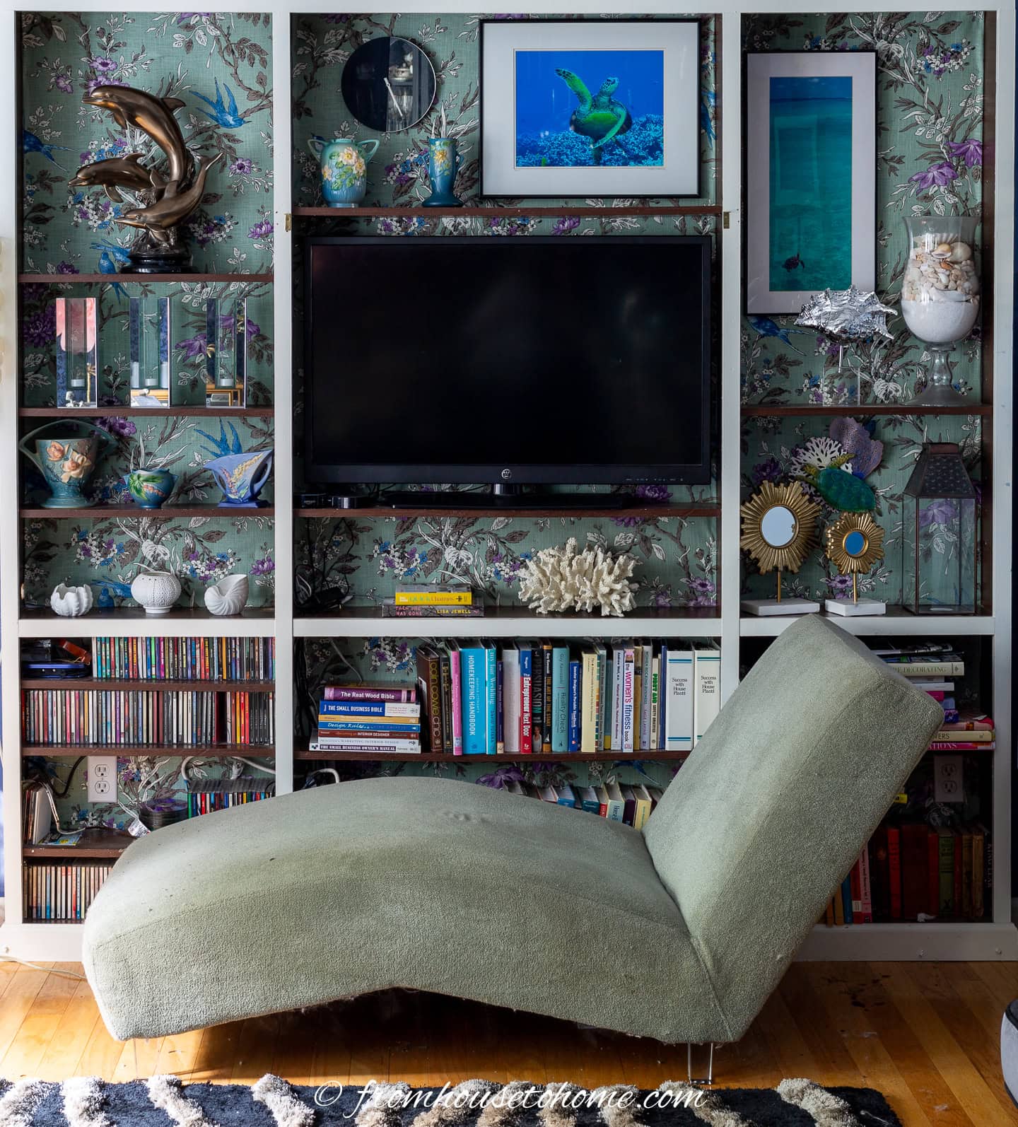TV in a bookshelf with a chaise in front of it