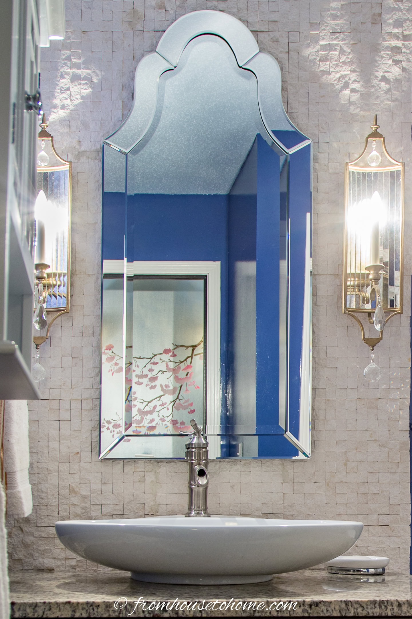 Split faced tile and a Venetian mirror help make this bathroom look more expensive