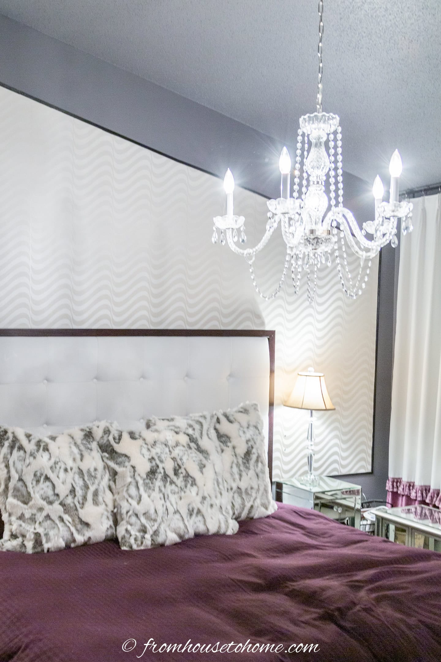 Master bedroom with a large chandelier over the bed