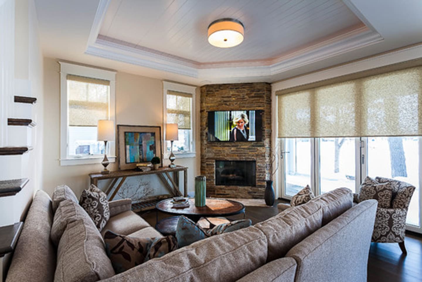 Sectional in front of a corner fireplace with a TV above it