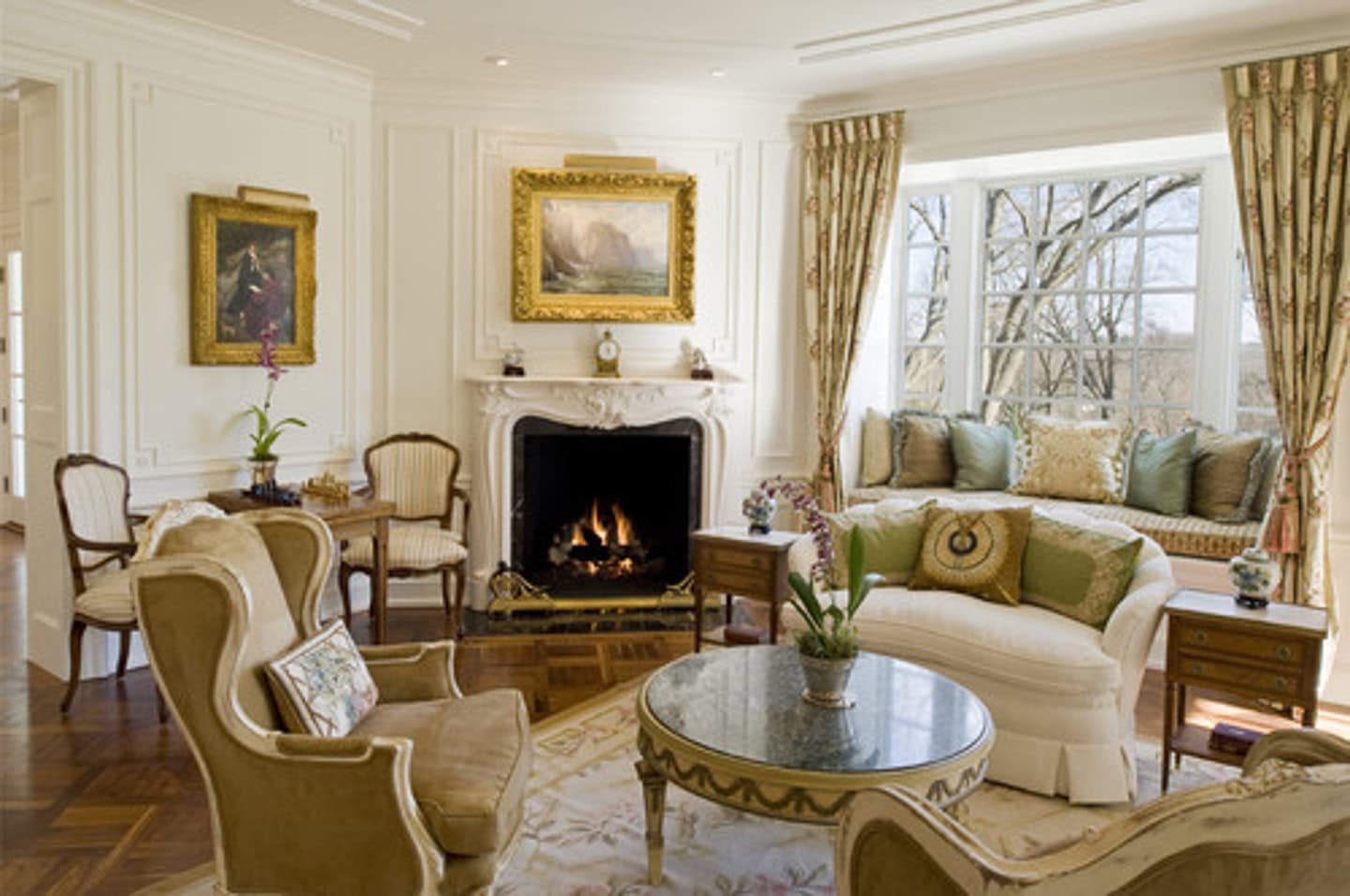 A living room with multiple small conversation areas in front of an angled fireplace