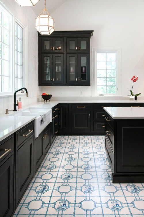 Black kitchen with white countertops and a blue and white floor