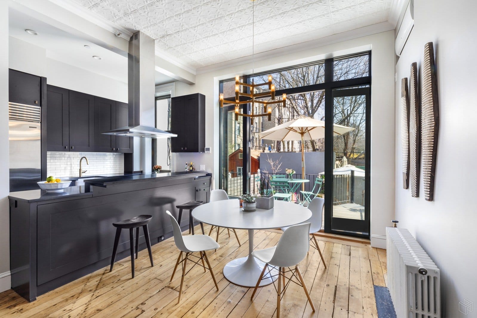 black kitchen with white backsplash and a wall of windows