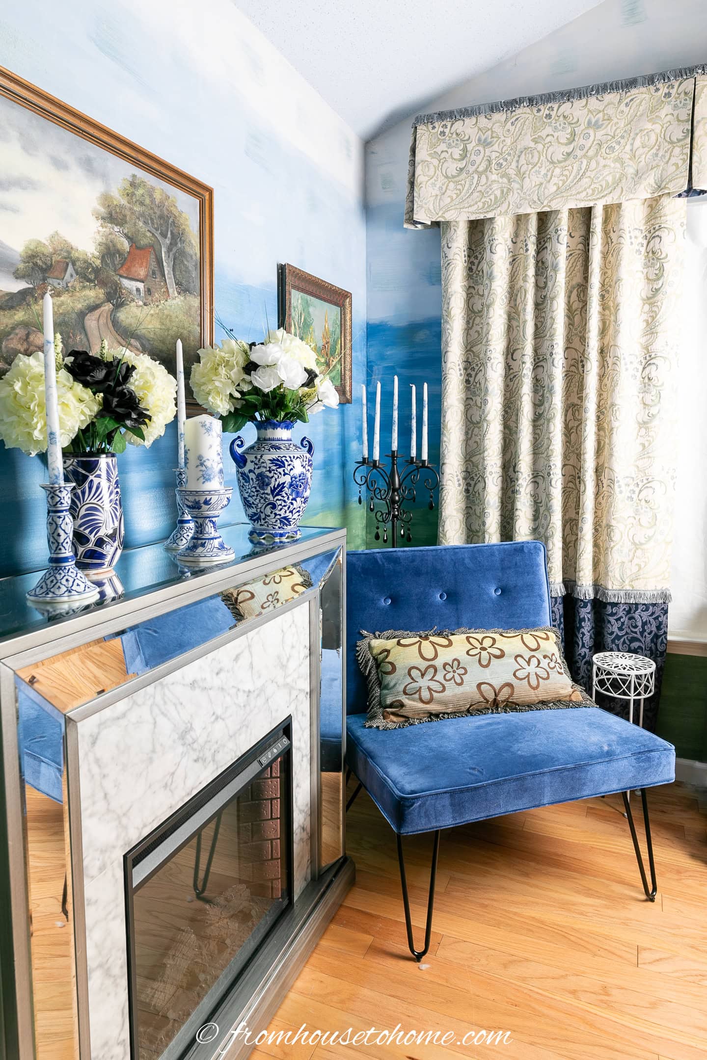 A blue chair beside an electric fireplace in a guest bedroom