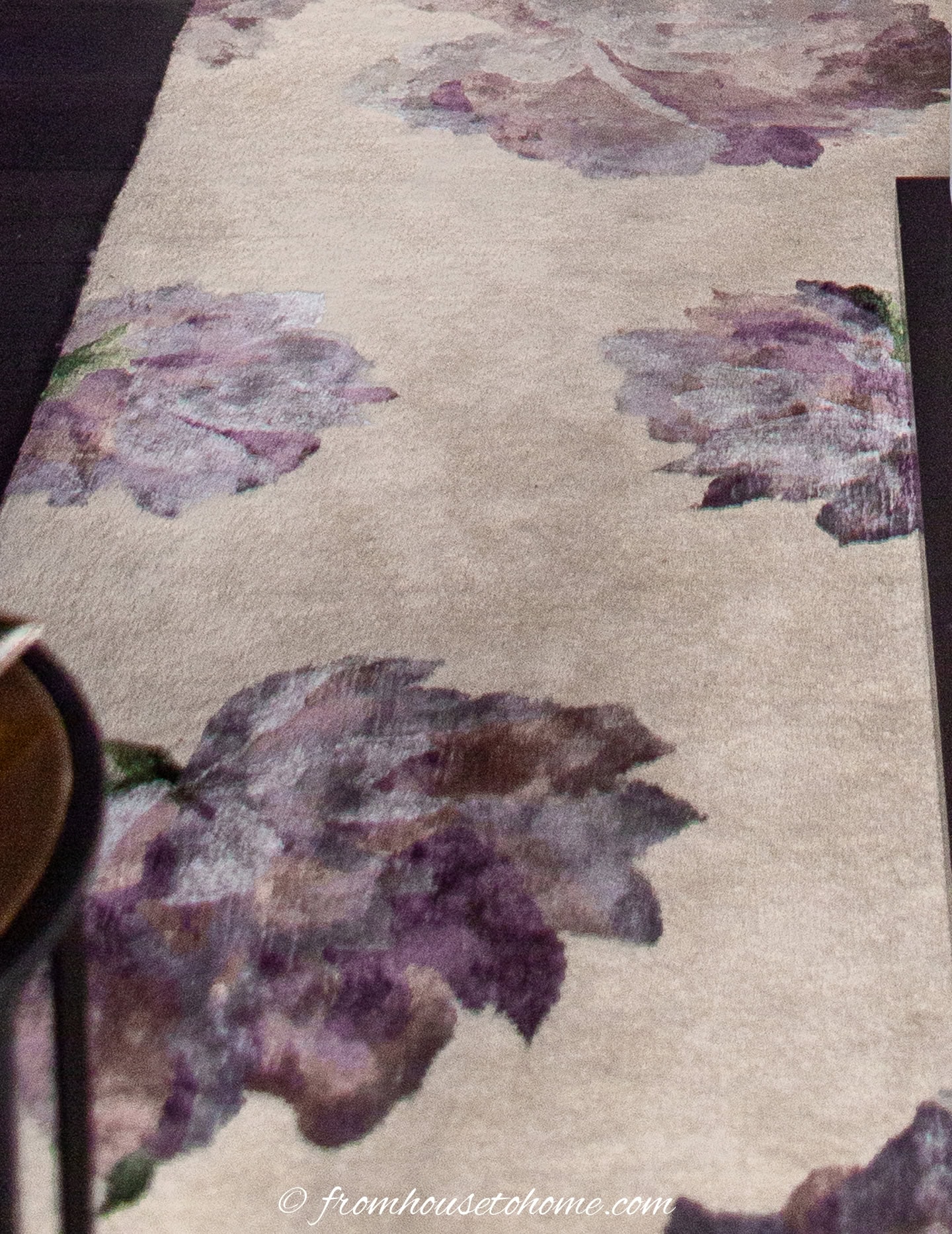 A close-up of a purple floral area rug
