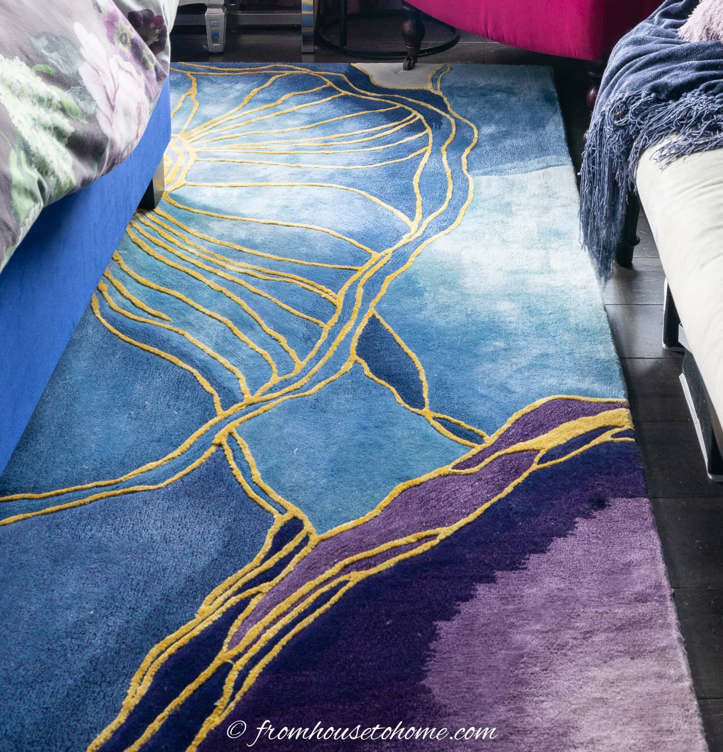 A closeup of an area rug with large blue and purple flowers