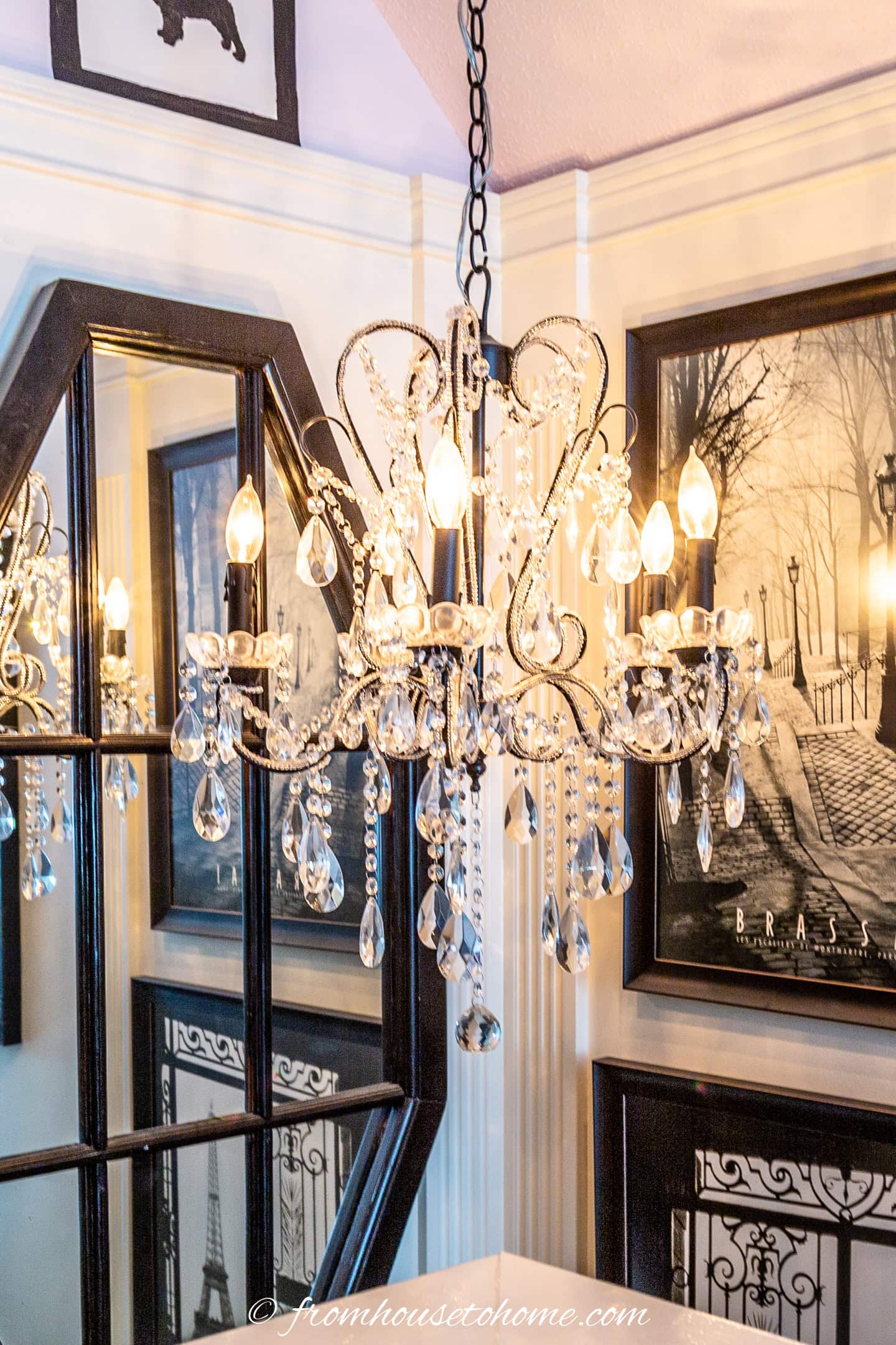 a chandelier hung in front of a mirror in a stairwell