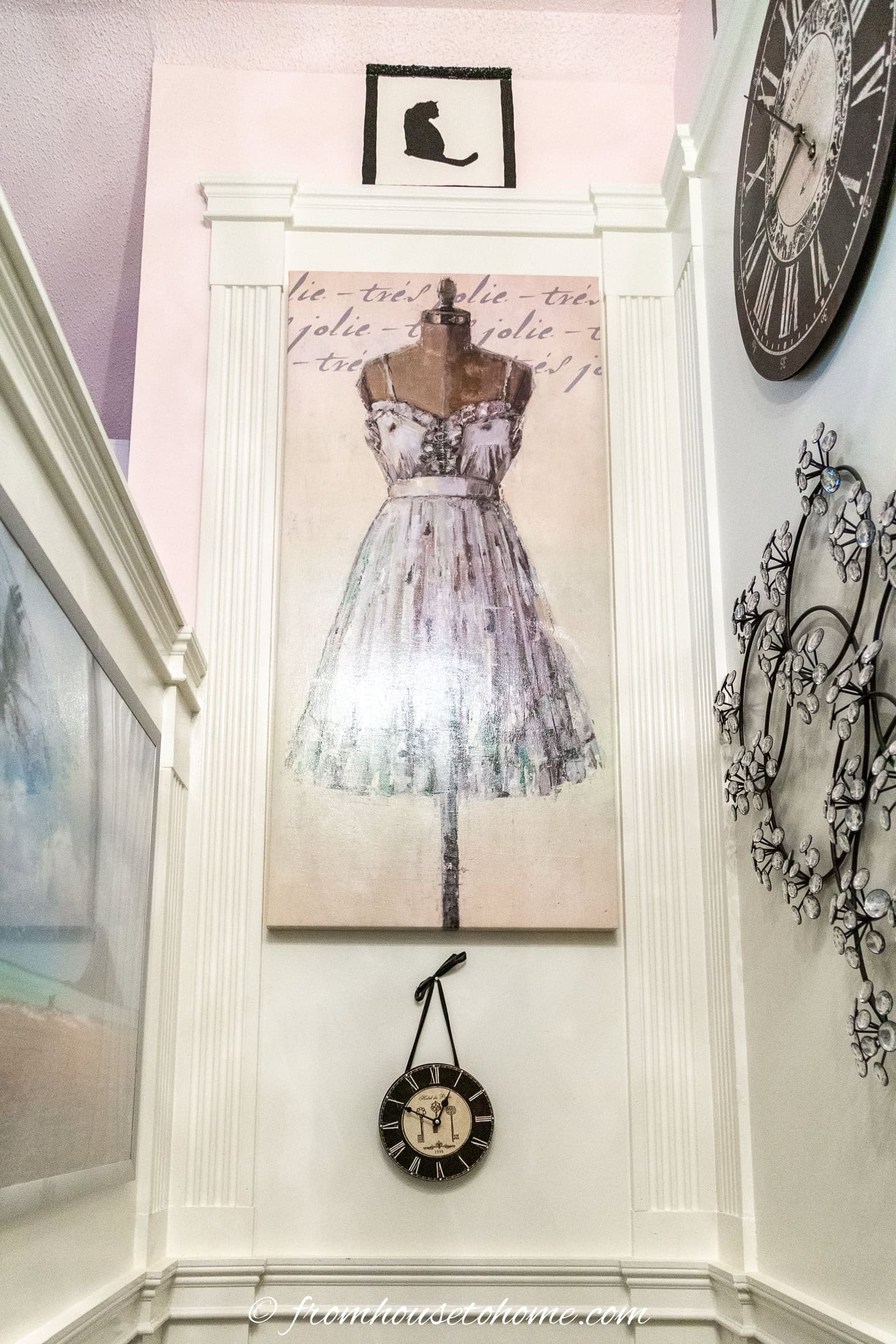 a large picture of a dress hung in a tall stairwell gallery wall