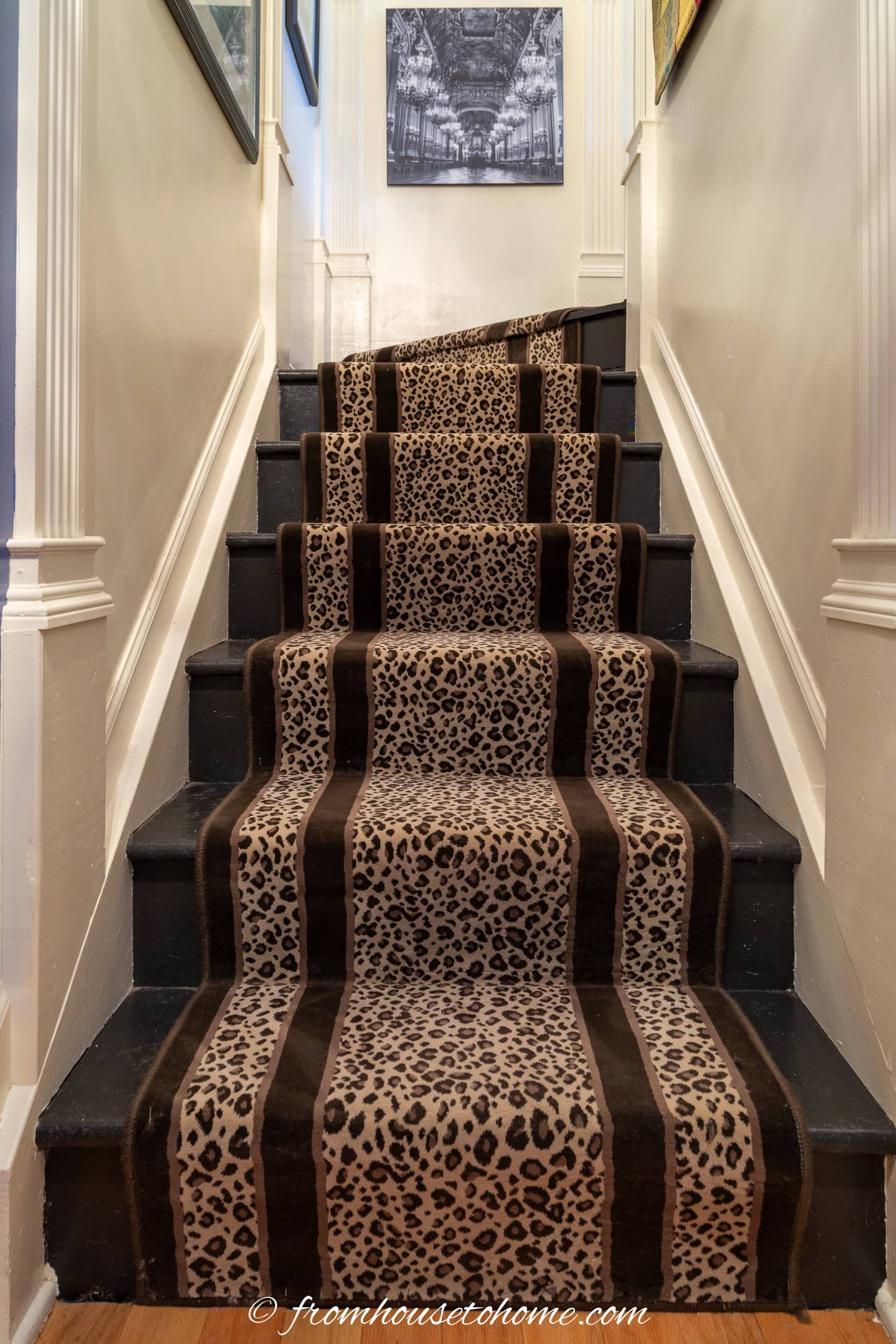 a leopard print runner on black stairs in a tall stairwell