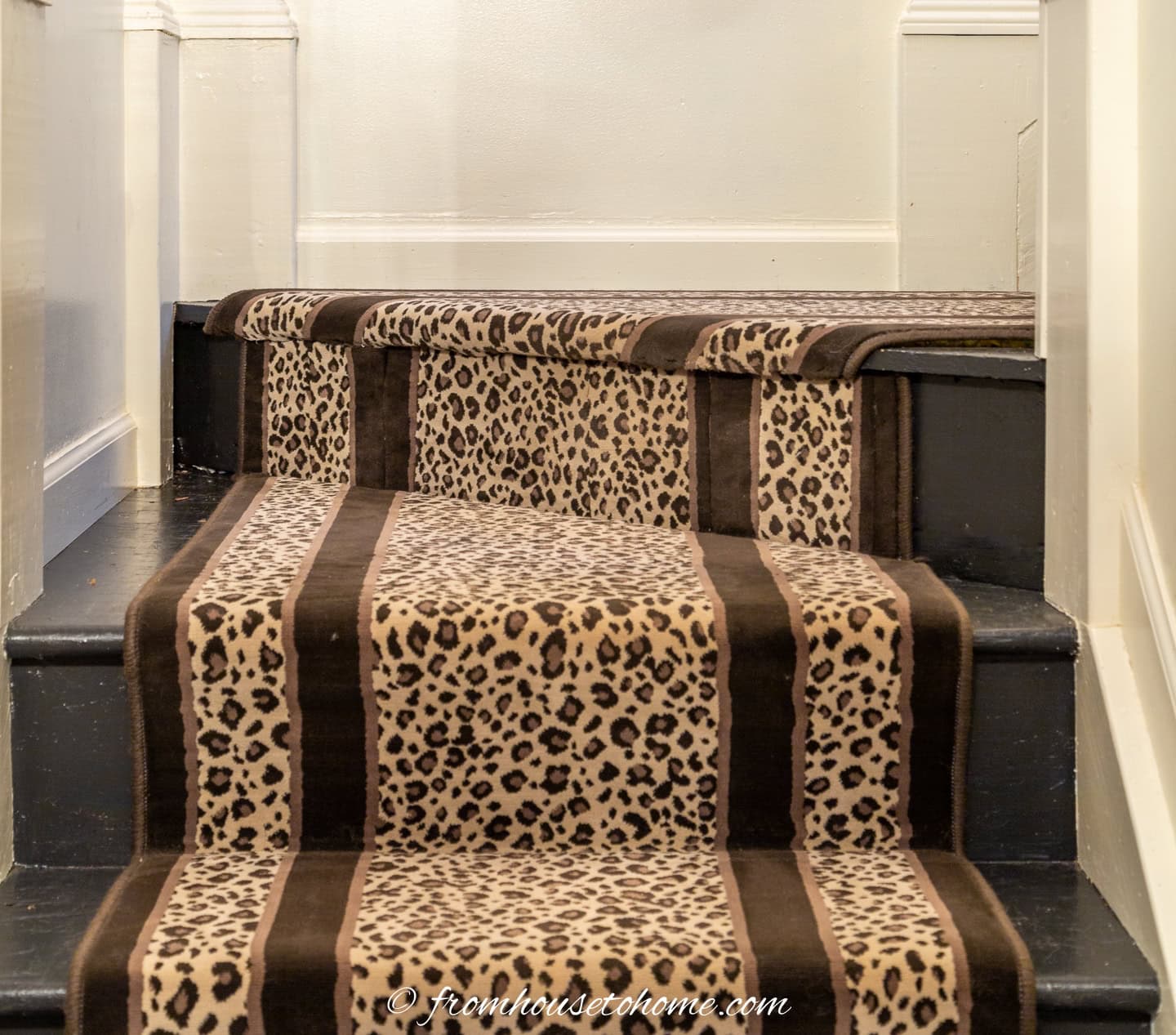 The join of leopard print runner with stripes on the sides at the bend in the stairway
