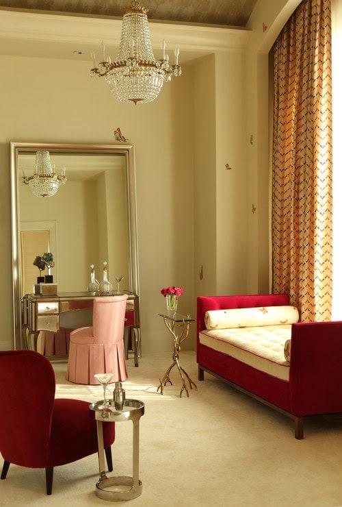 A large floor mirror with a mirrored desk and pink chair in front of it