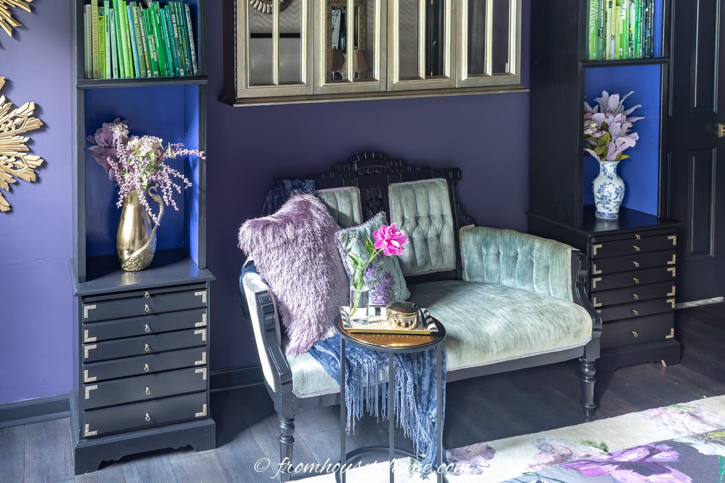 Two glam painted nightstands on either side of a settee in a bedroom