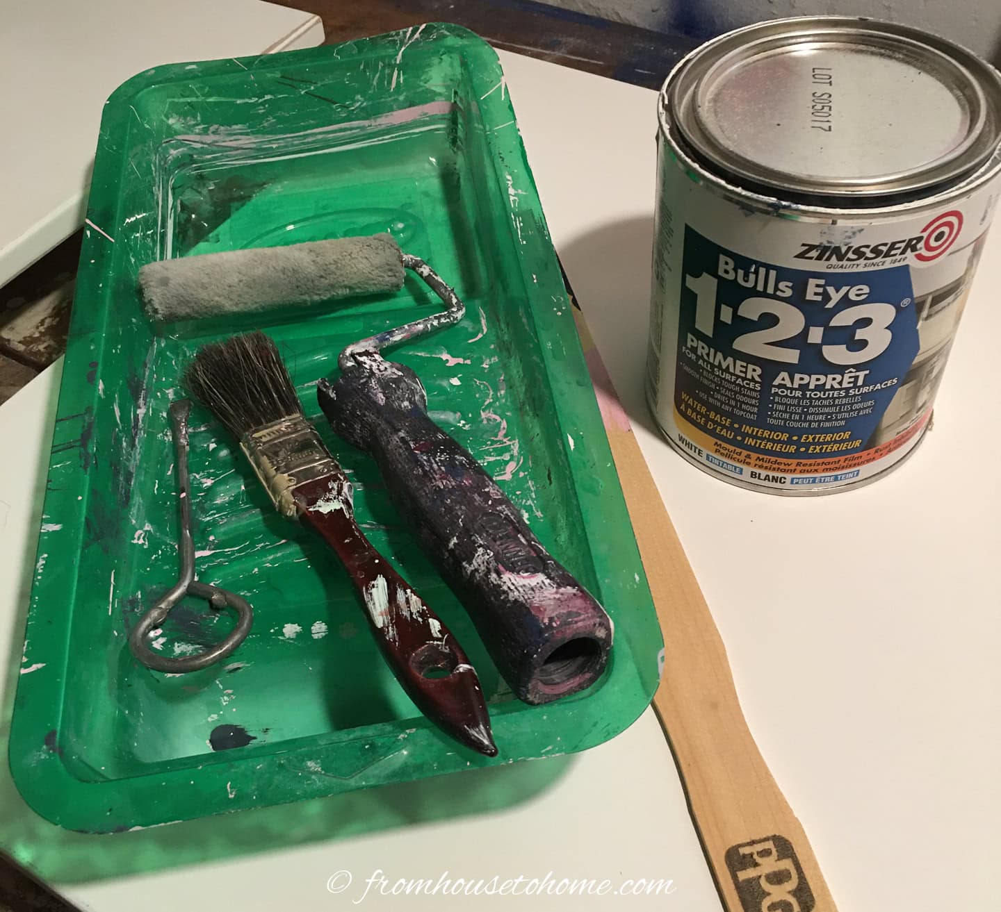 Zinsser Bulls Eye 1-2-3 primer beside a paint tray, roller and brush