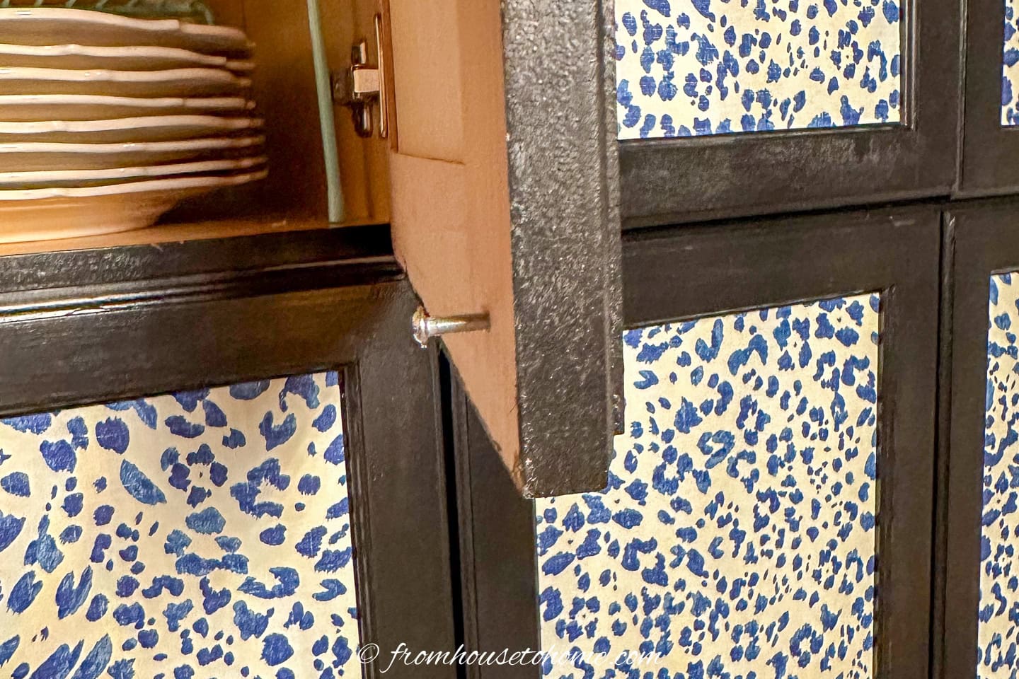 Screw in the back of a kitchen cabinet door for the knob