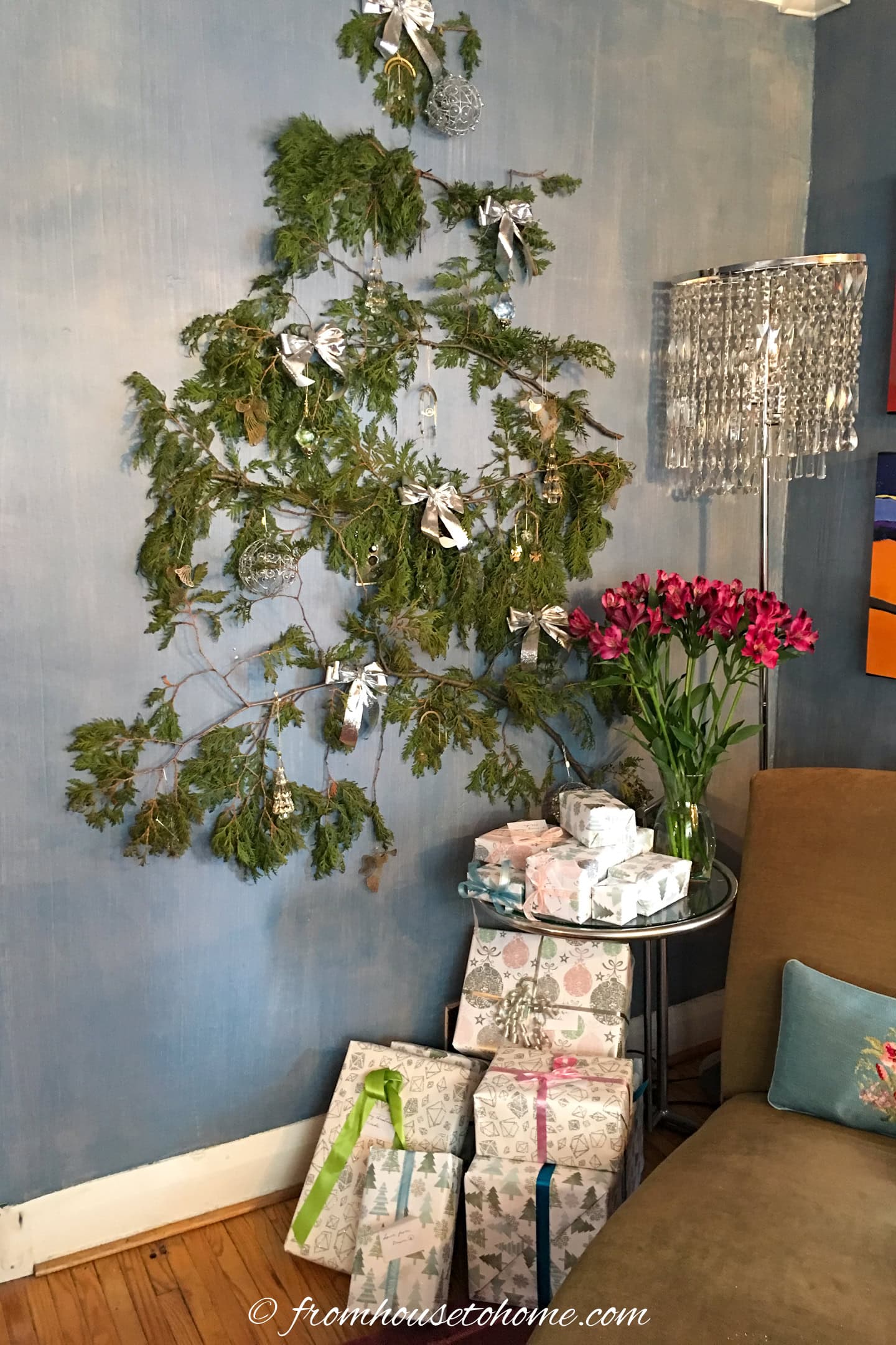 Wrapped Christmas presents under a wall mounted flat Christmas tree