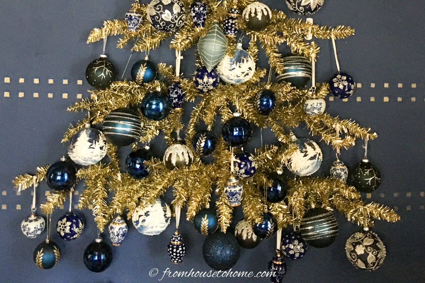 Lots of ornaments hung on the branches of a wall Christmas tree
