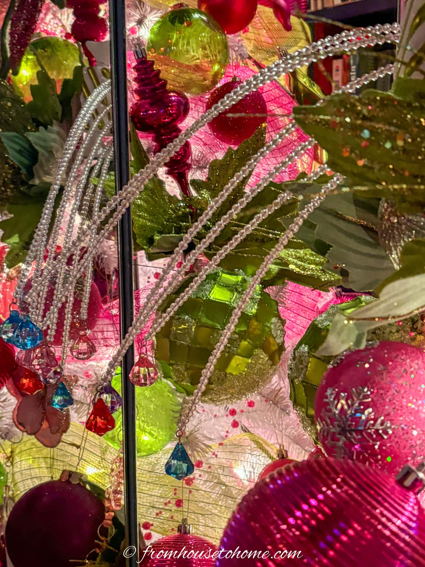 close up of lime green and fuchsia pink ornaments and pinks on a white christmas tree