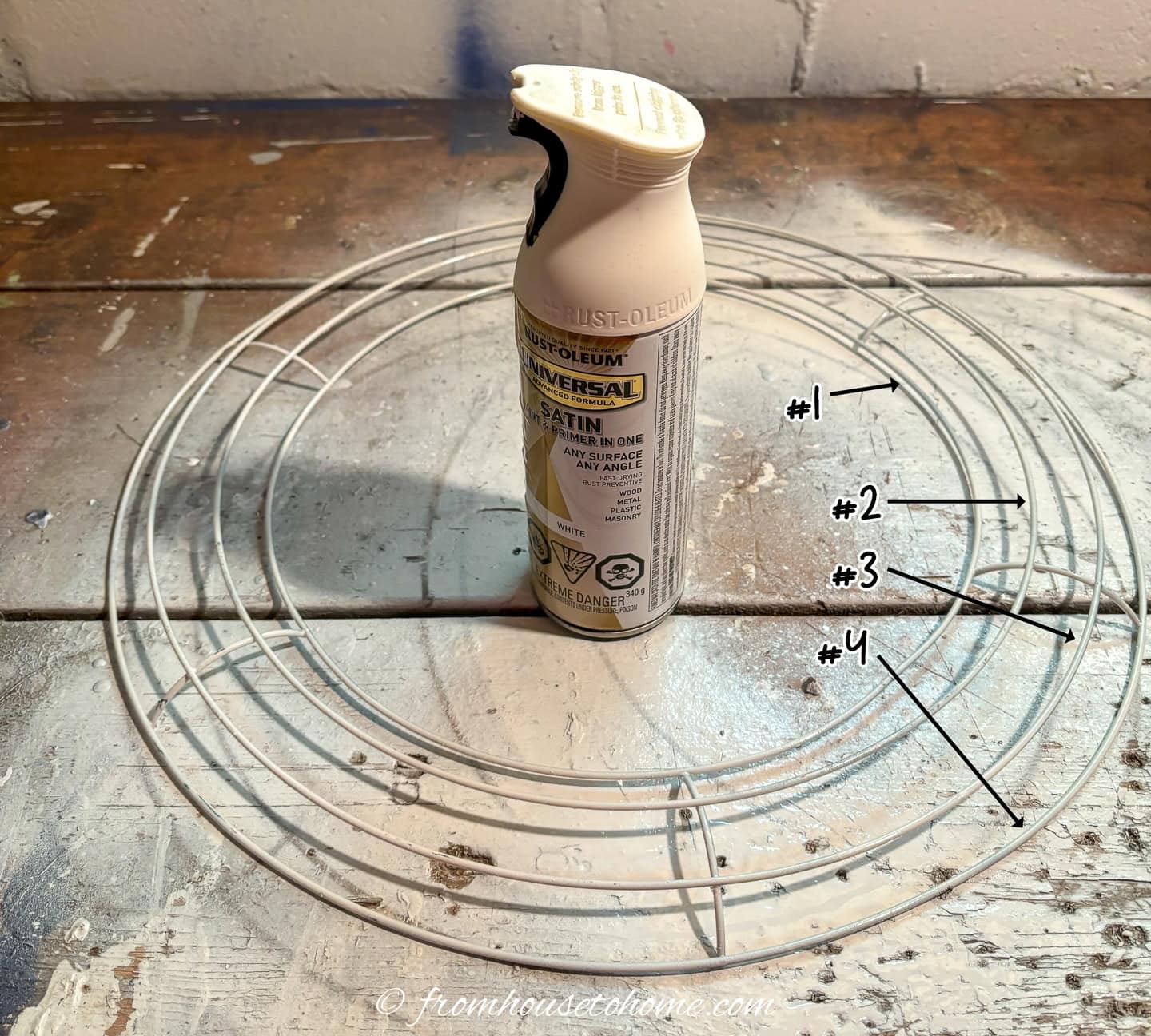can of white spray paint inside a wire wreath form that has been spray painted white